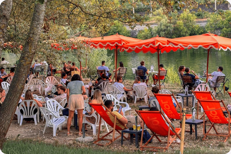 Vacances d'été à Lyon : Guinguette avec parasols et transats au bord de l'eau à Lyon en été